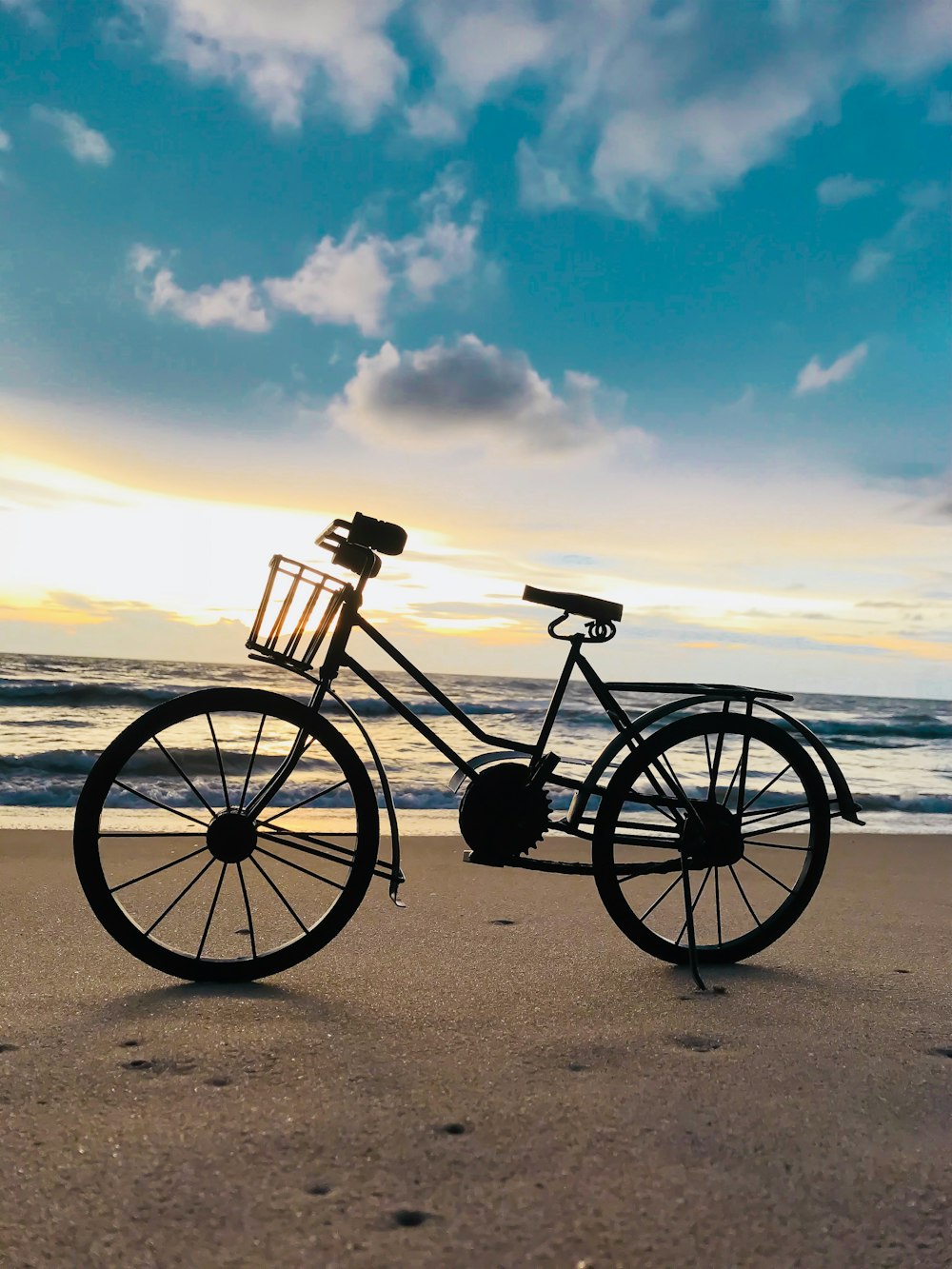 black beach bike on seashore viewing blue sea under white and blue sky during daytime
