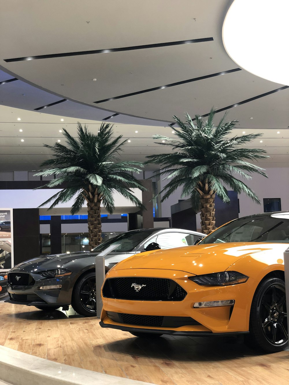 two orange and gray Ford Mustang coupes