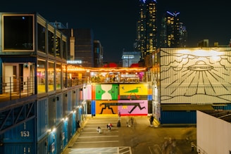 A vibrant urban-themed container hotel with city skyline.