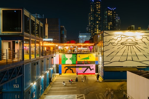 A vibrant urban-themed container hotel with city skyline.