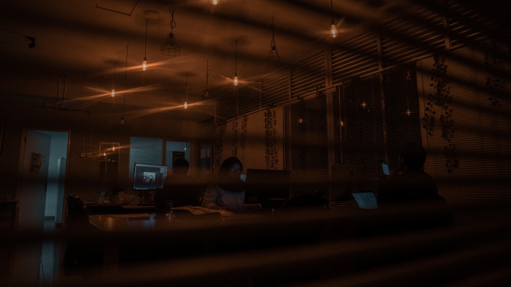 a person sitting at a desk in a dark room