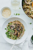 A close-up of a creamy mushroom risotto garnished with fresh herbs