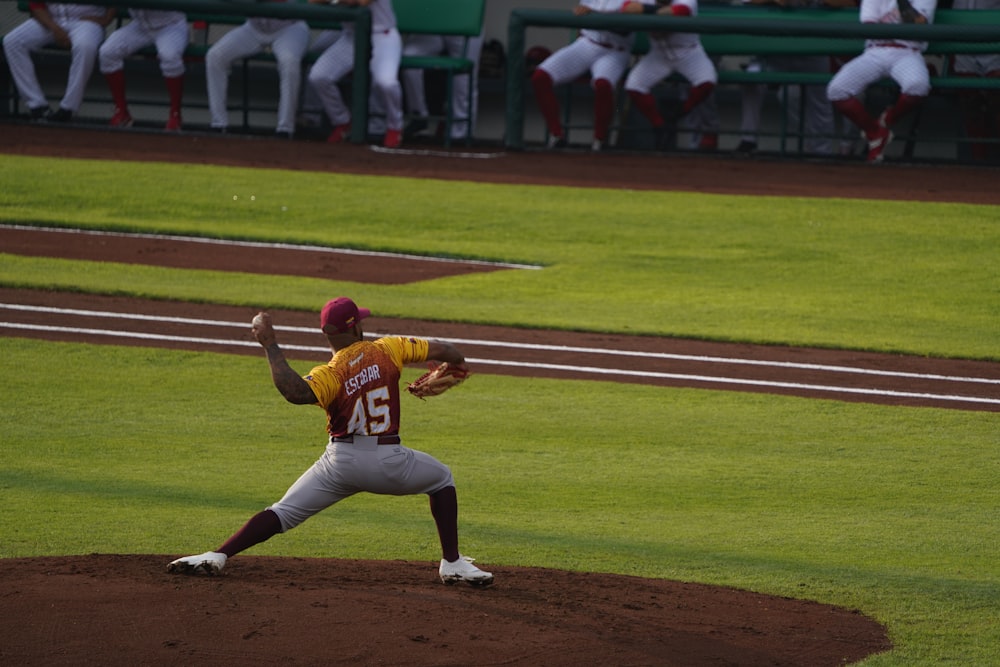 a baseball player pitching a ball on top of a field