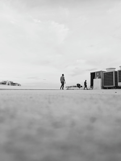 Monochrome photo of engineers reviewing solar panel installations on a rooftop with clear geometric lines