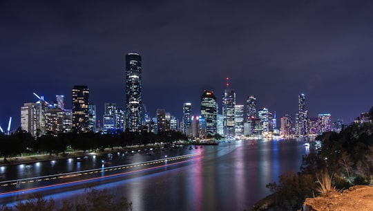 city skyline lights reflecting on body of water at night in Kangaroo Point Cliffs Park Australia