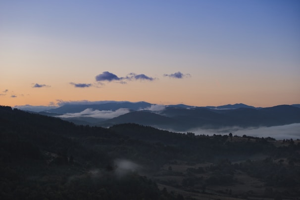 A serene sunrise over a misty mountain range, perfect for mindful morning hikes.