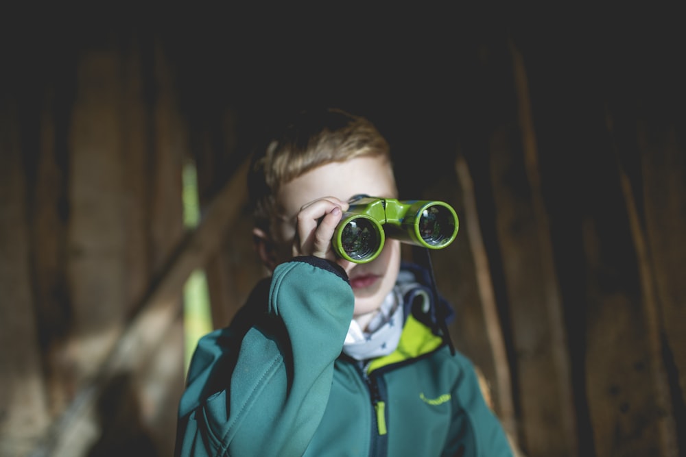 boy using green binoculars