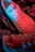 A close-up view of stylish sneakers featuring a gradient lighting effect with hues of red and blue. The sneakers have a label on the tongue and are positioned on a textured surface that resembles crumpled paper.
