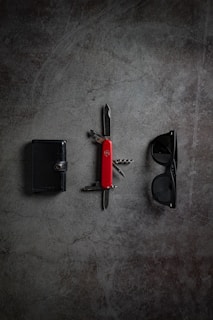 An elegant wallet arranged next to a pair of sunglasses.