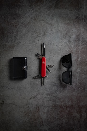 An elegant wallet arranged next to a pair of sunglasses.
