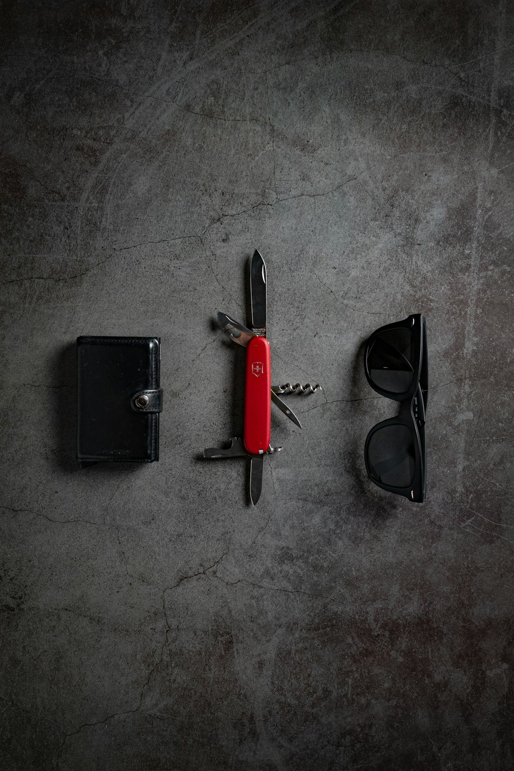 rotes Schweizer Messer und schwarze Sonnenbrille