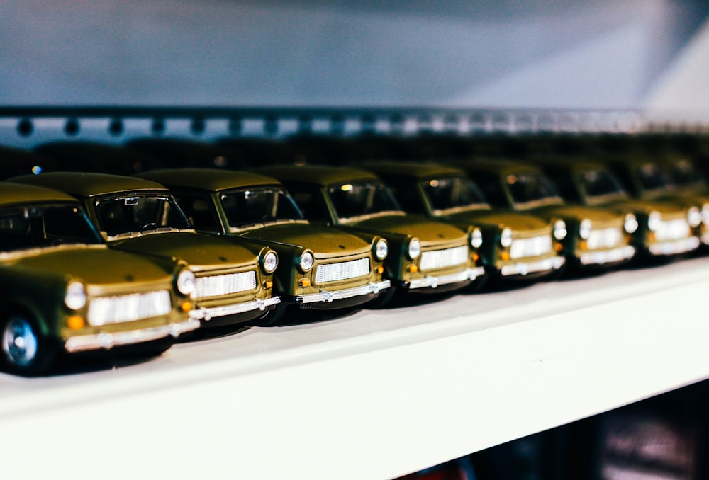 uma fileira de carros de brinquedo sentados em cima de uma prateleira