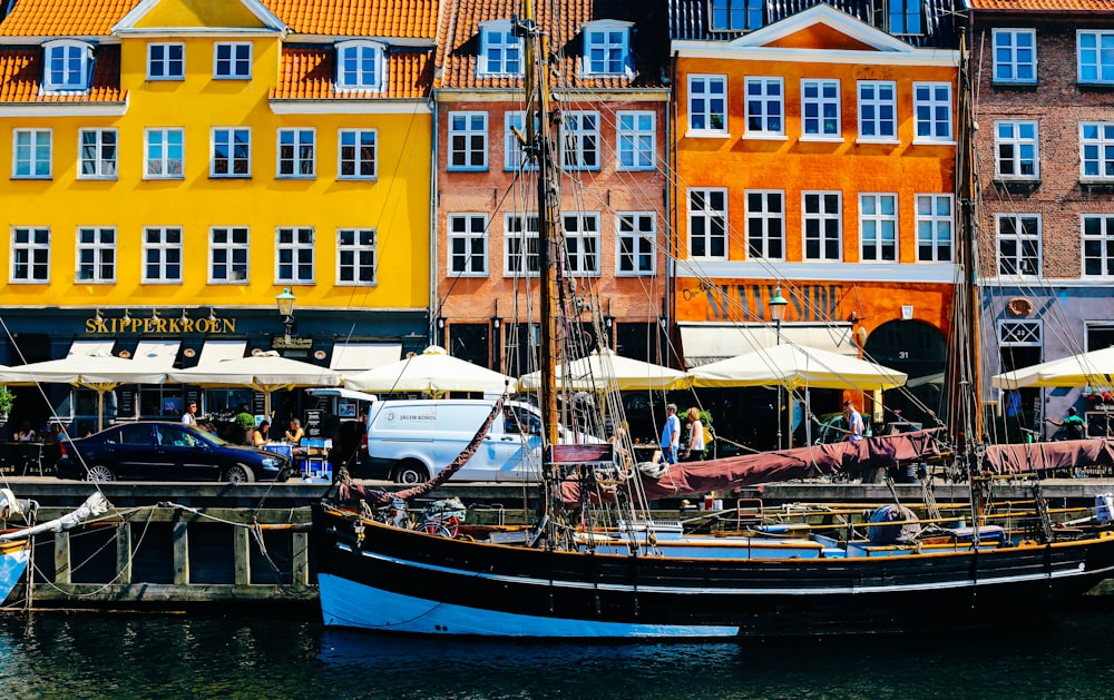 boat at dock by colorful houses during daytime