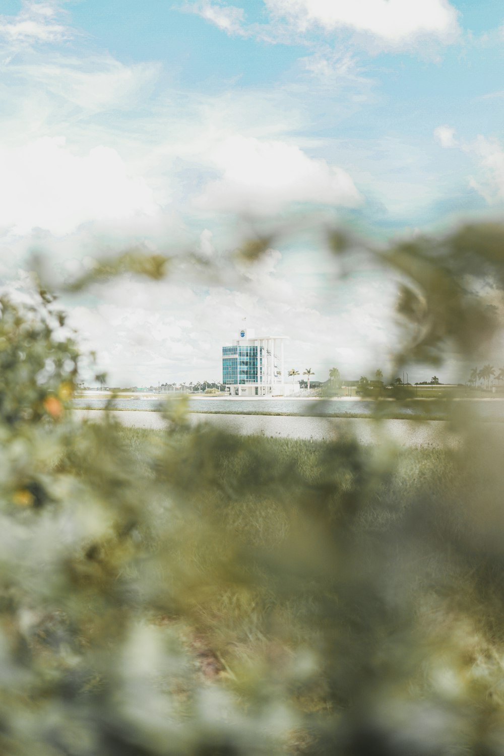 white and green high-rise building under white and blue sky during daytime