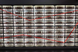 A vibrant display of colorful craft beer bottles and cans arranged on a sleek black shelf with gold accents.