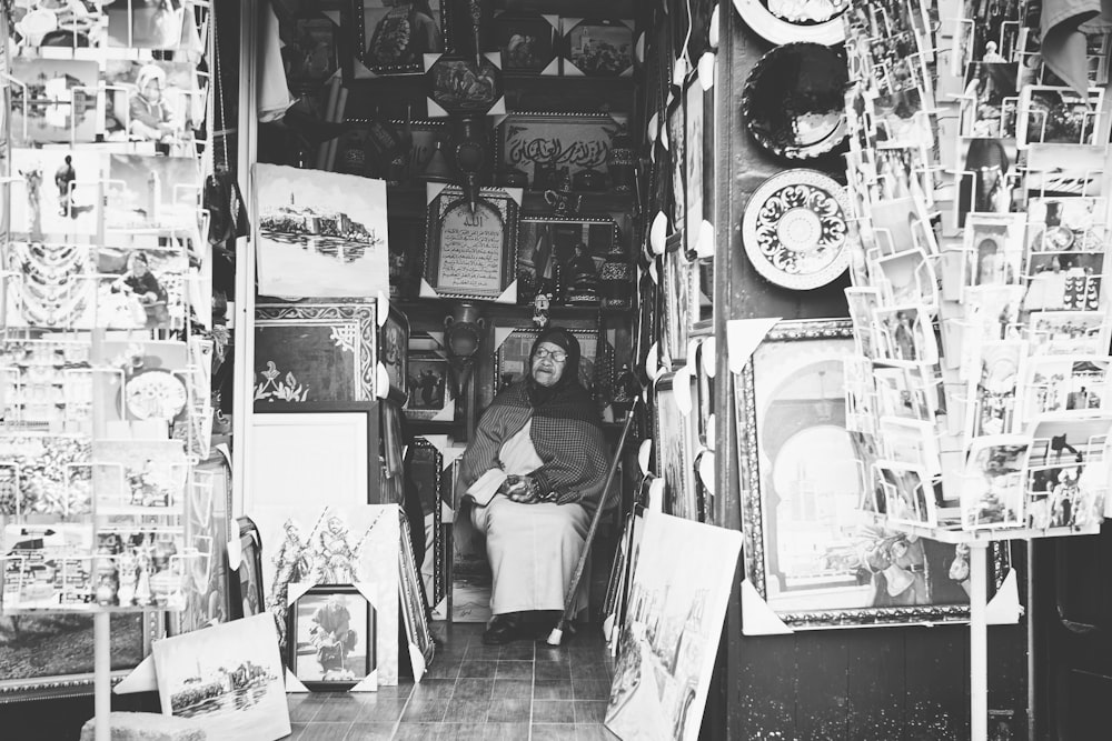 grayscale photography of woman sitting inside store