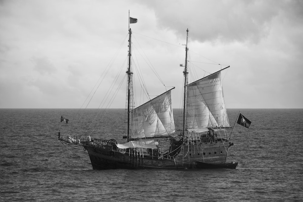 Photographie en niveaux de gris d’un bateau sur un plan d’eau