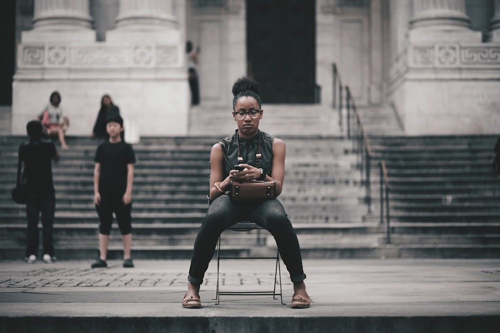 woman sitting on black chair \