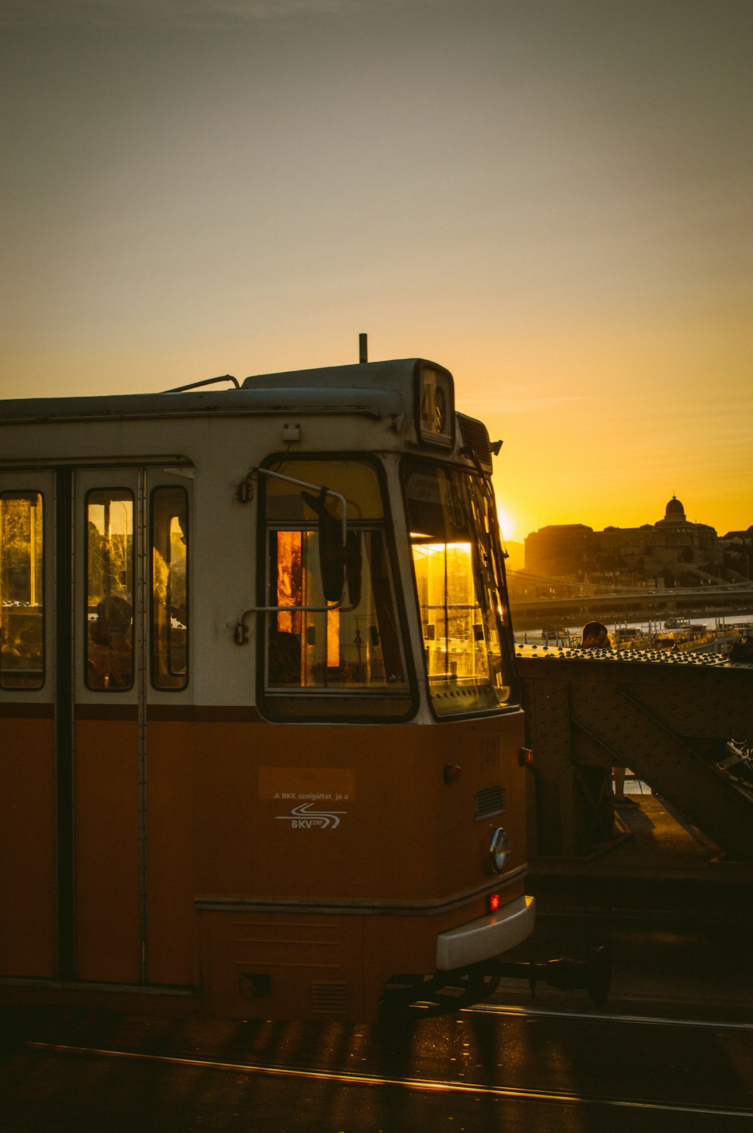 white and orange tram under yellow sky