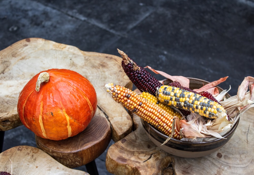 corn in cob near orange pumpkin