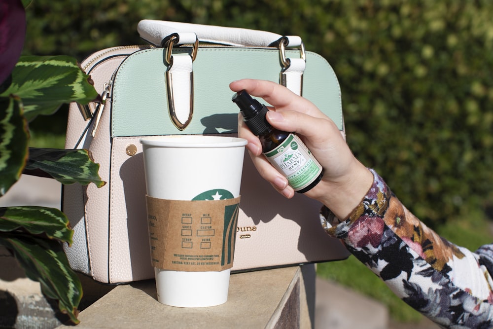 white Starbucks disposable cup beside handbag