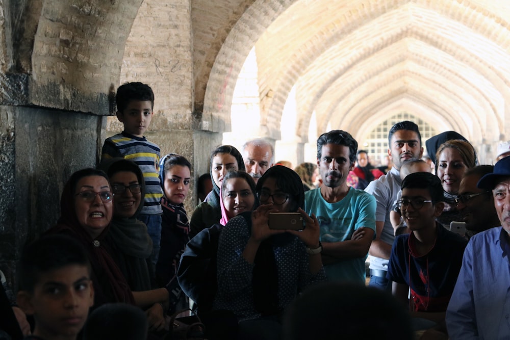 group of people gathering under concrete shed