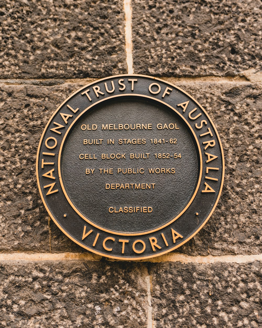 Moneda redonda marrón y negra del National Trust of Australia Victoria