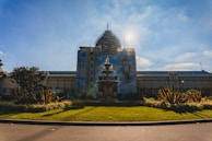 Exterior shot of a hotel facade being repaired and restored under bright Mediterranean sunlight.