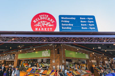 A vibrant market scene in Melbourne with colorful stalls and lively crowds.