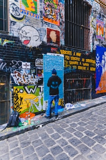 Close-up of a graffiti artist painting a colorful wall in an urban alley