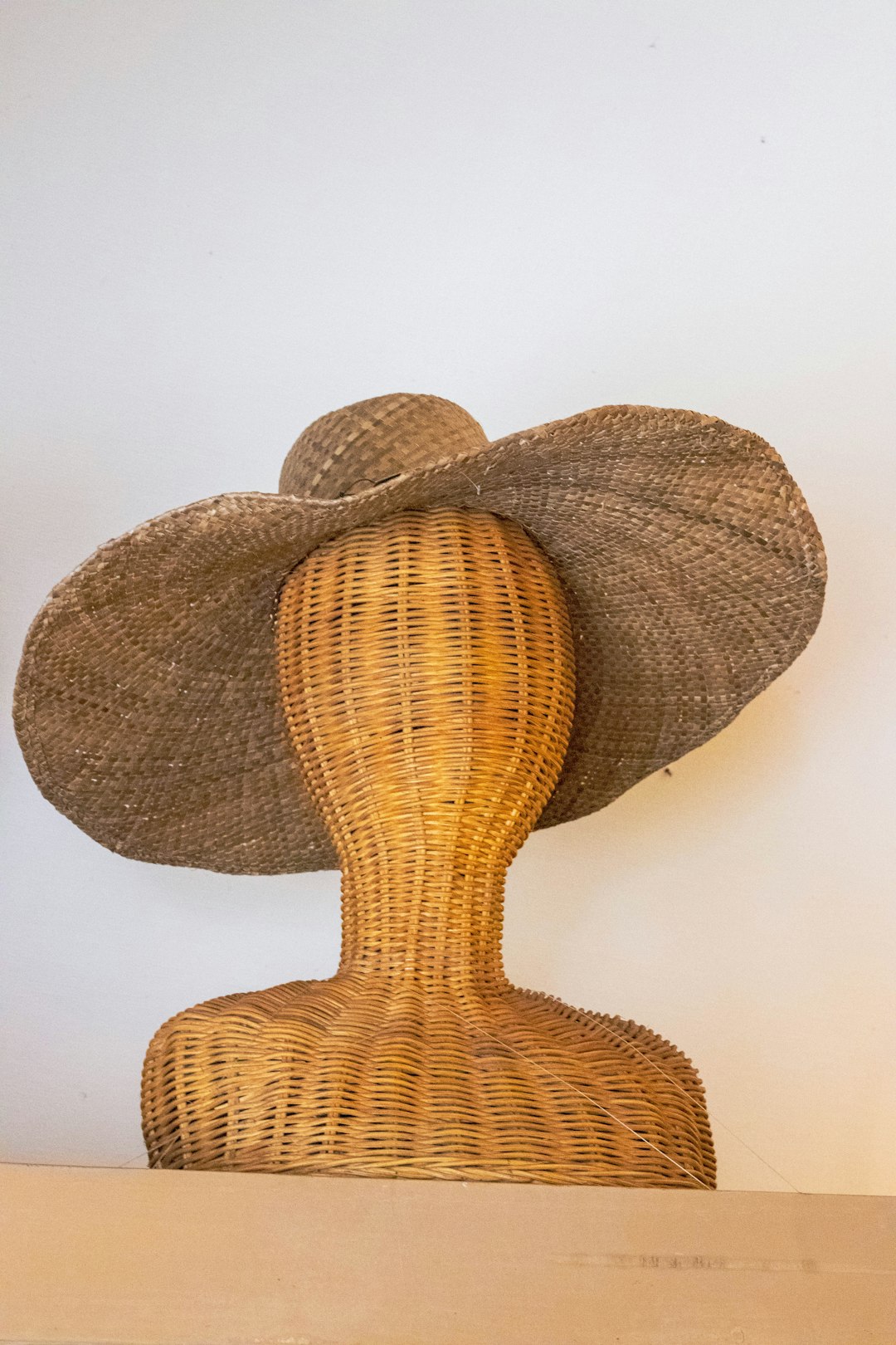 brown strawhat on brown wicker mannequin