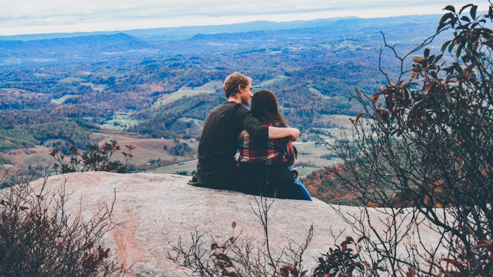 couple sitting on the mountain feld
