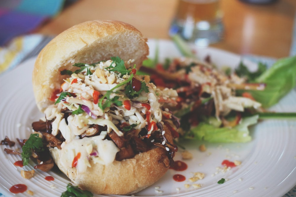 Patty mit Krautsalat und Schinken auf weißem Teller