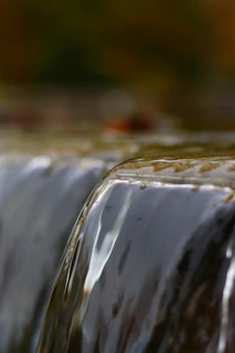 Close-up of a detailed artisan waterfall with smooth water flow and earthy tones.