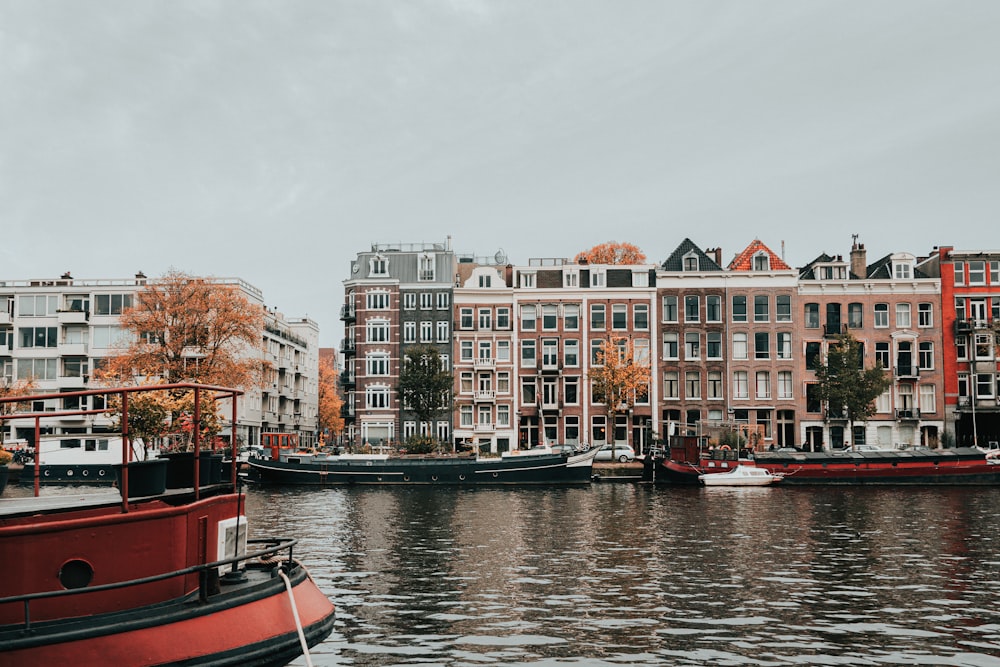 boats floating on body of water beside concrete buildings