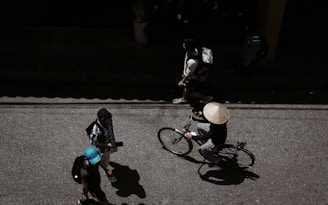 man standing beside man riding bike