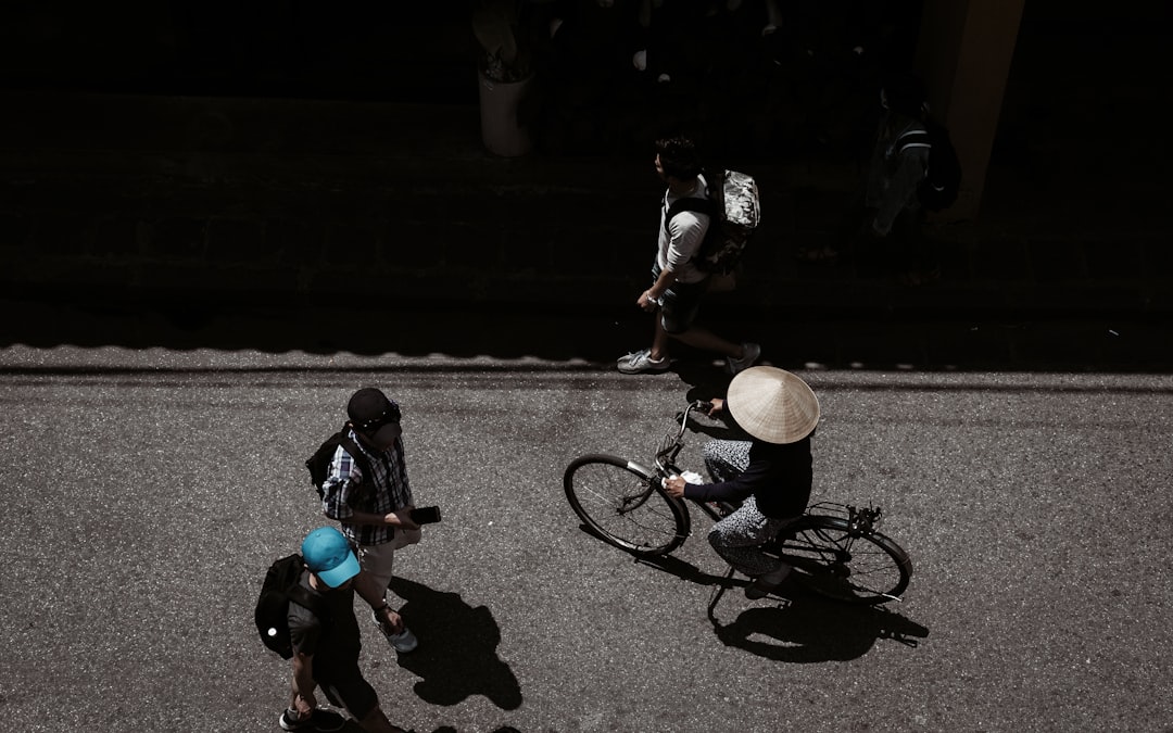 man standing beside man riding bike