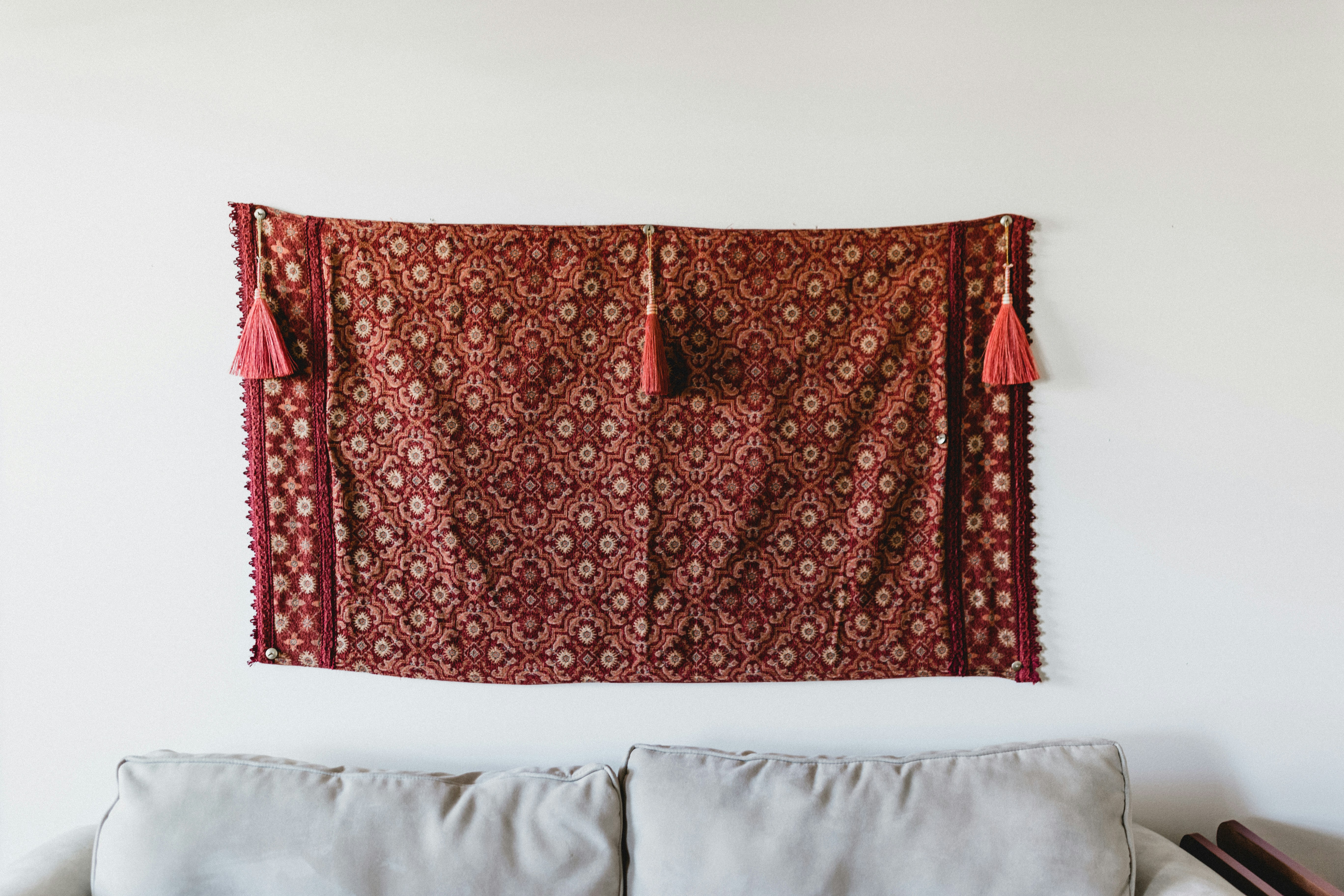 red and orange fabric wall decor near white couch