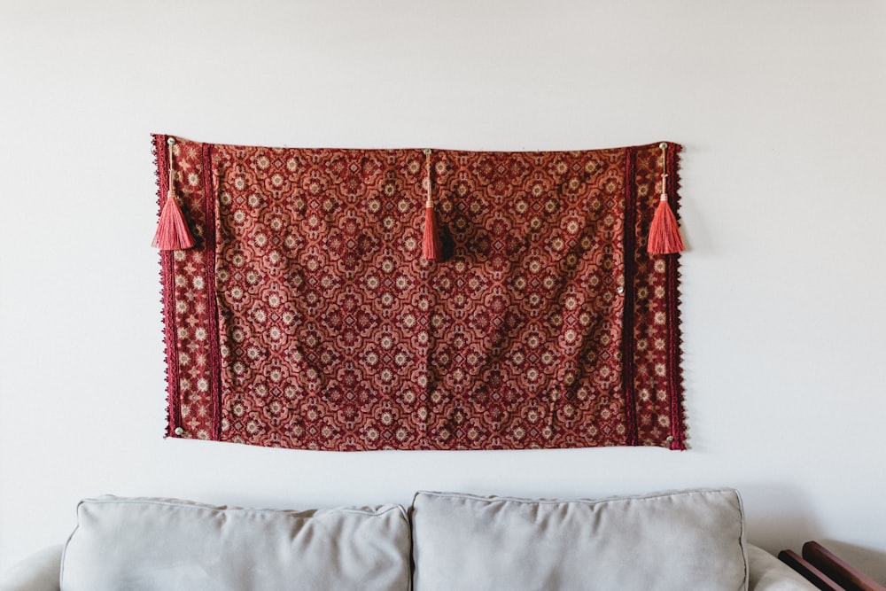 red and orange fabric wall decor near white couch