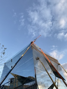 High-resolution image of a modern architectural building under construction with clear blue sky background.