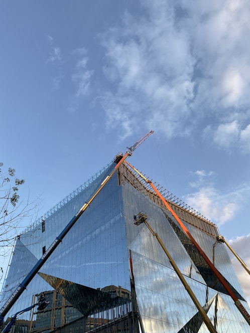 A vibrant construction site showing workers framing a modern residential building under a clear blue sky.