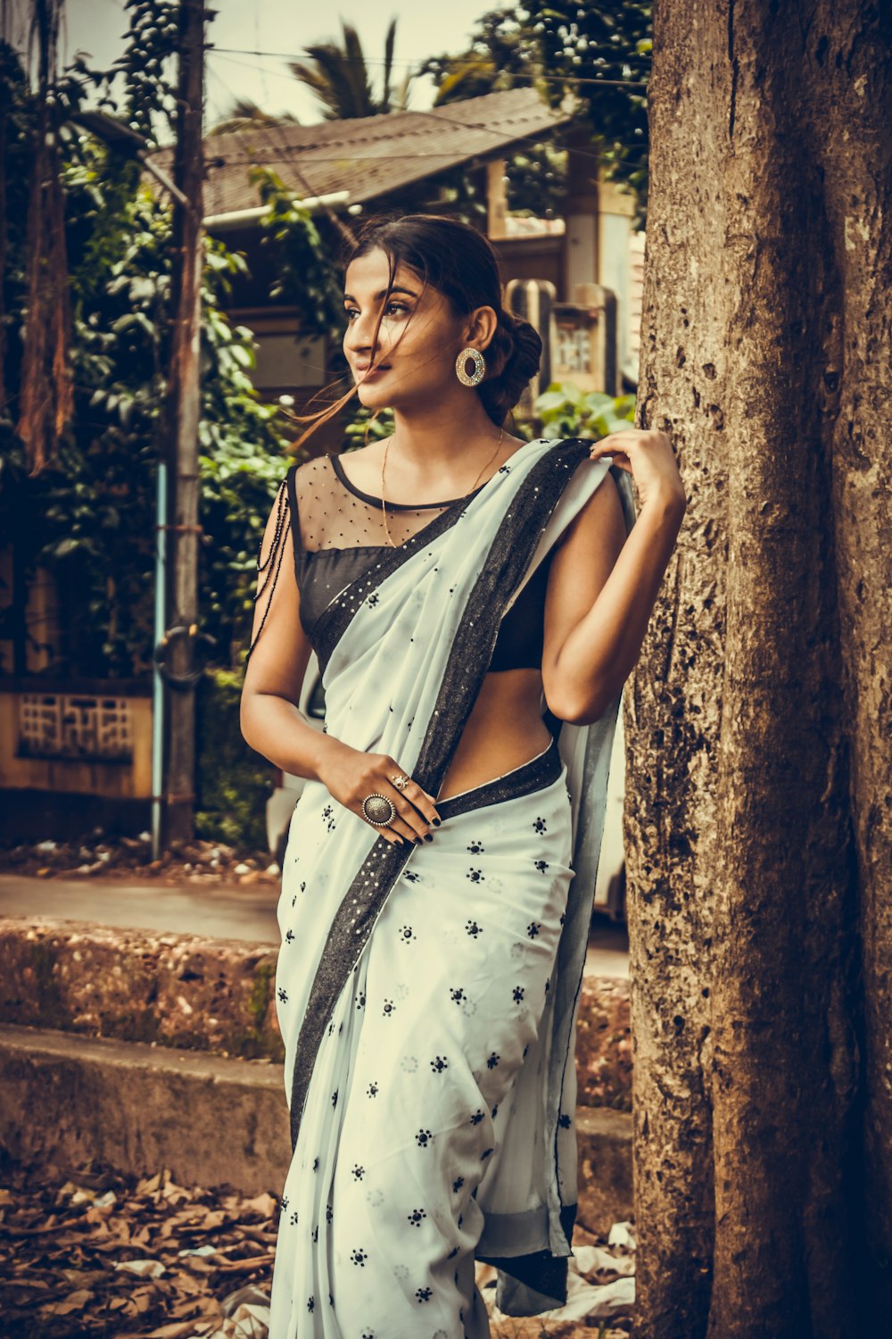 woman wearing black and white saree dress standing on tree