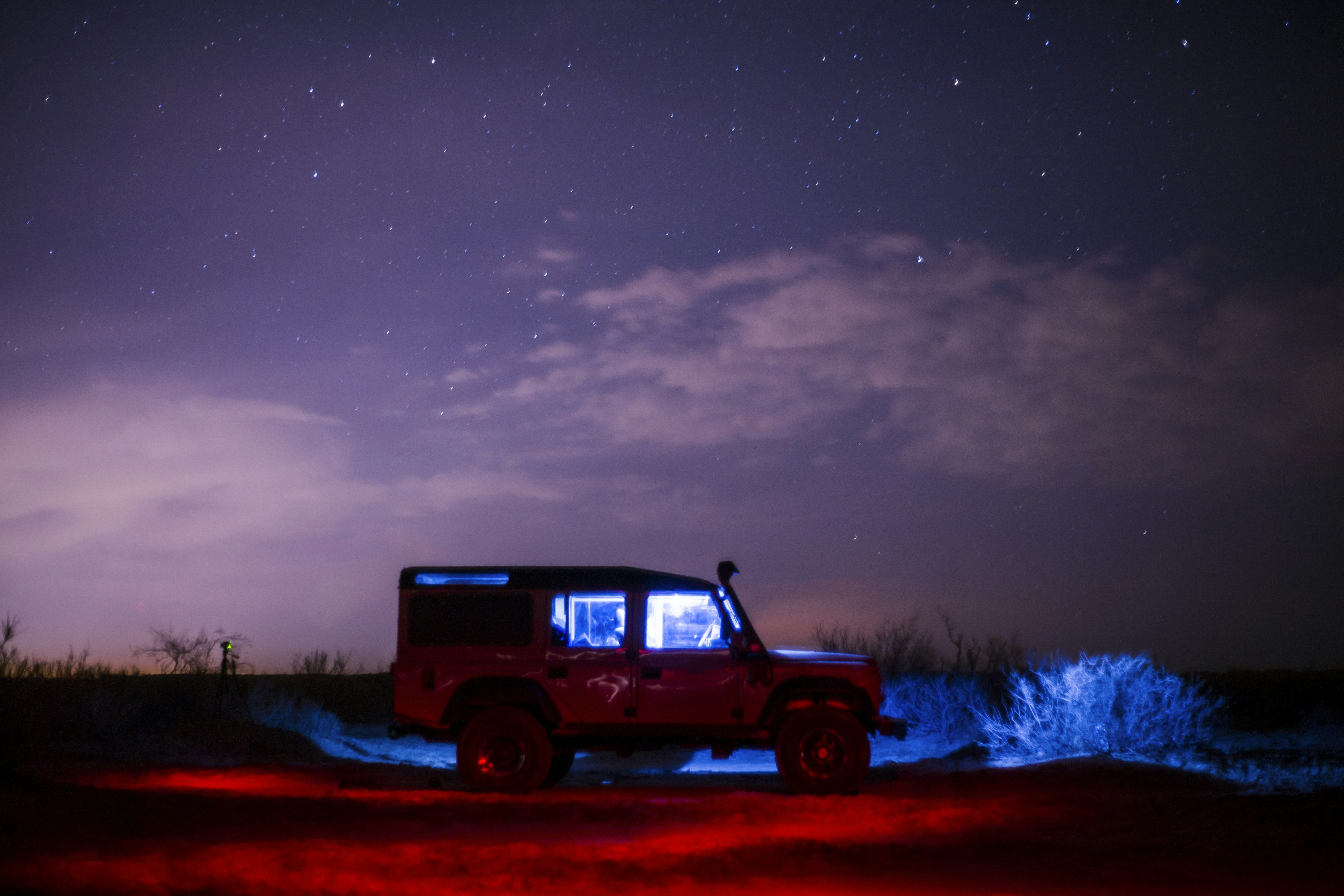 white and black SUV under white and blue sky during night time, 
