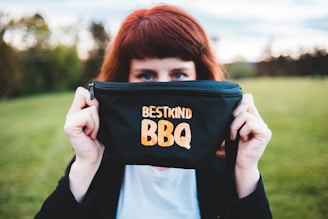 A rugged trucker holding a 10 lb bag of Great American Beef Jerky with an American flag waving in the background.
