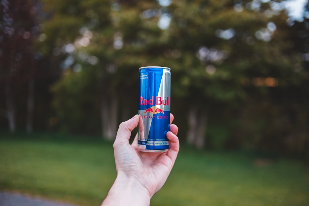 person holding Red Bull energy drink can
