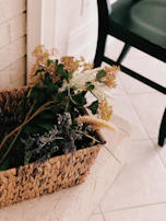 Decorative woven basket filled with fresh flowers on a cozy living room floor.