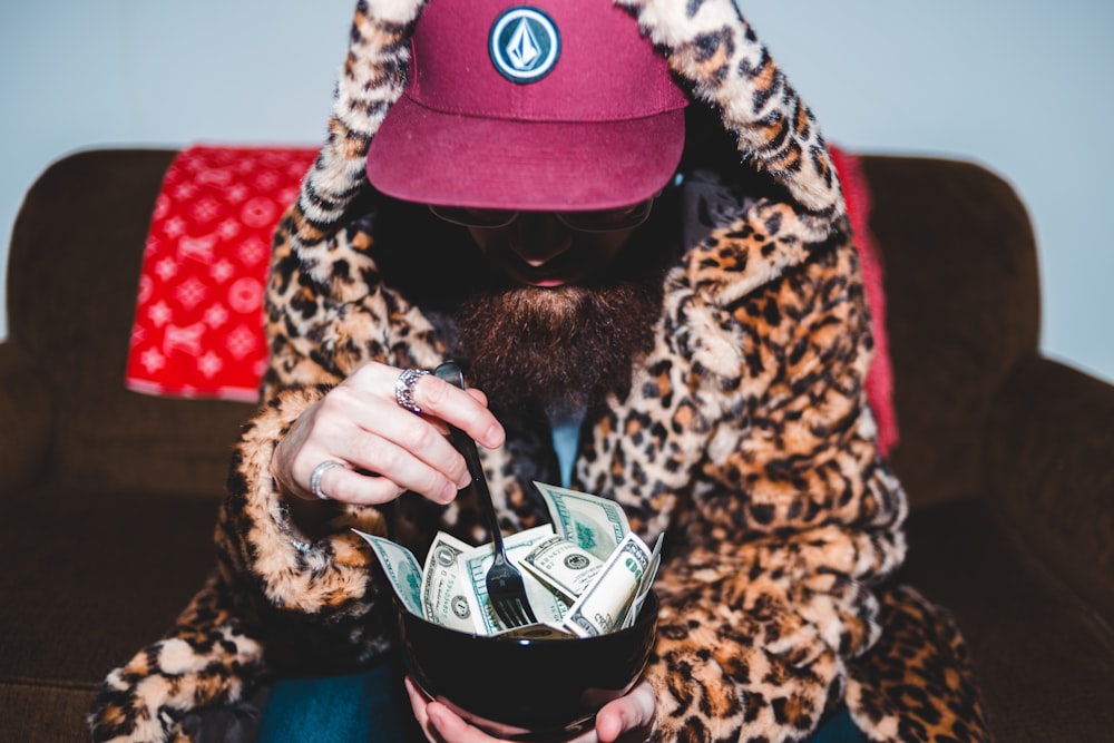 person holding bowl full of money