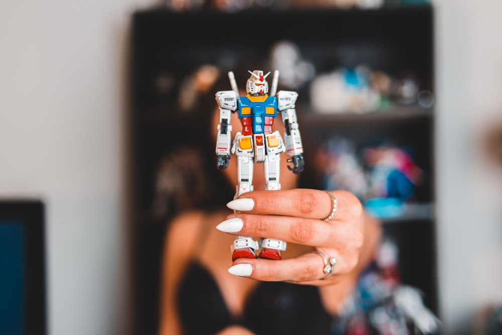 selective focus photography of a person holding Gundam WIng toy