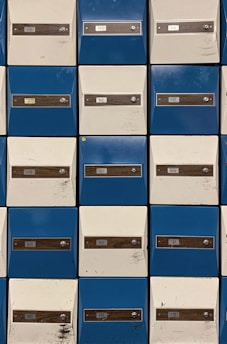 Close-up of a mailbox rental area with secure, numbered mailboxes in blue and white.