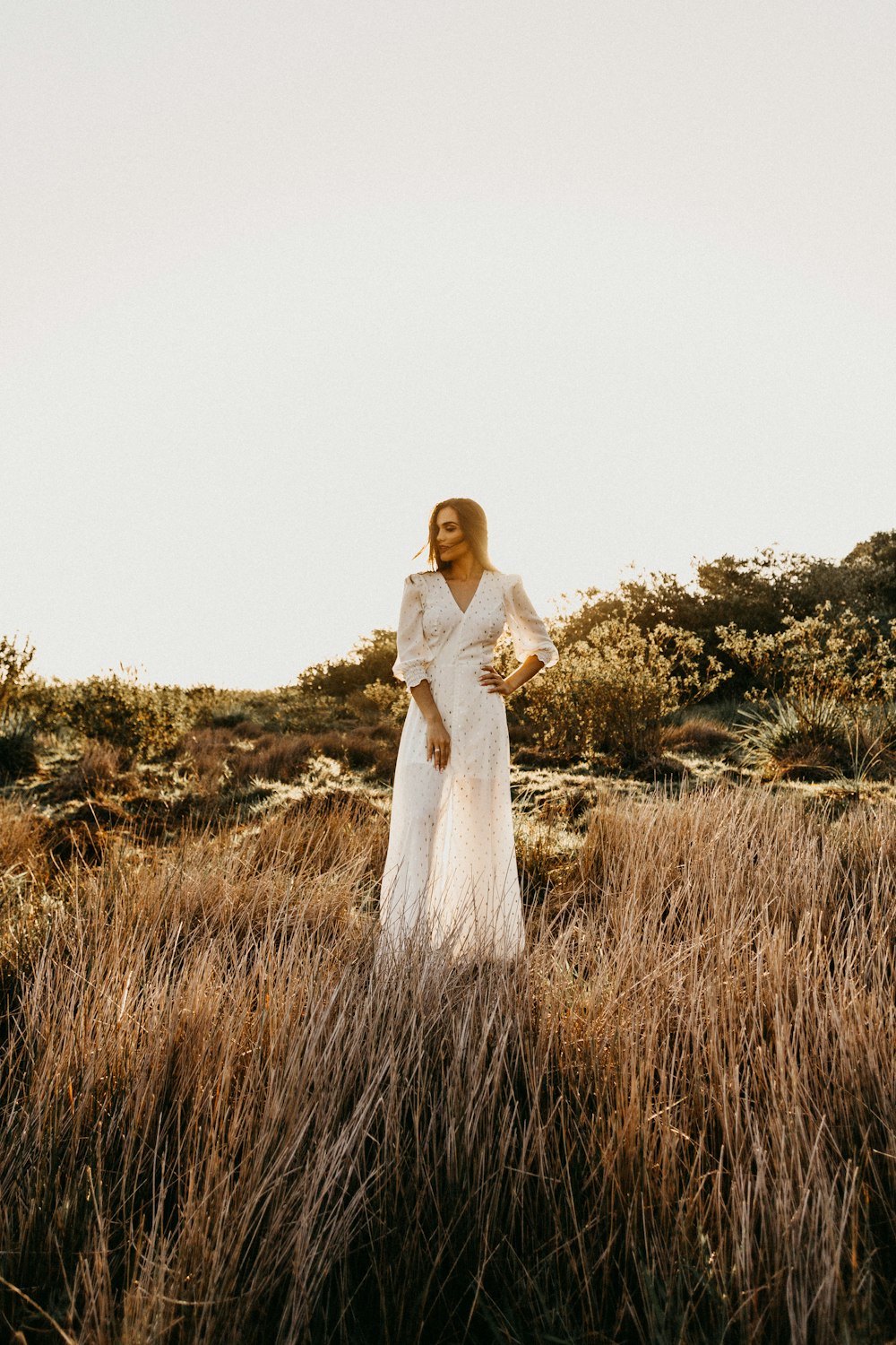 femme en robe blanche au champ pendant la journée